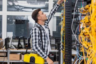 young-network-engineer-with-box-looking-at-ethernet-switches